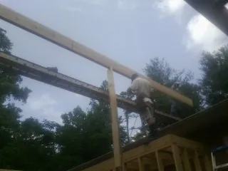 Carpenter setting a ridge beam over a new addition frame — Ice Dam Removal by Roofing Brothers in Whites Creek