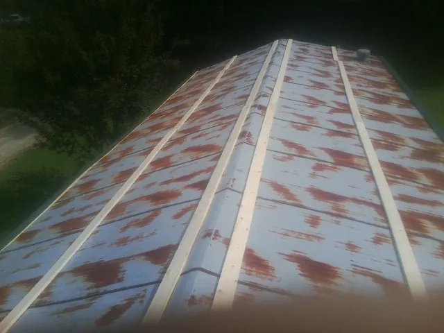 Rusted metal roof panels with new wood purlins before replacement — Storm Damage Roof Repair in Whites Creek by Roofing Brothers