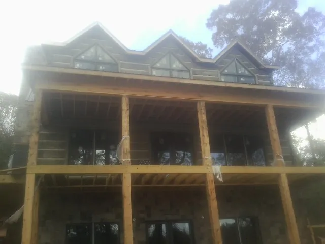 Dormers and porch framing on a large log home under construction — Roof Coating work by our crew in Whites Creek