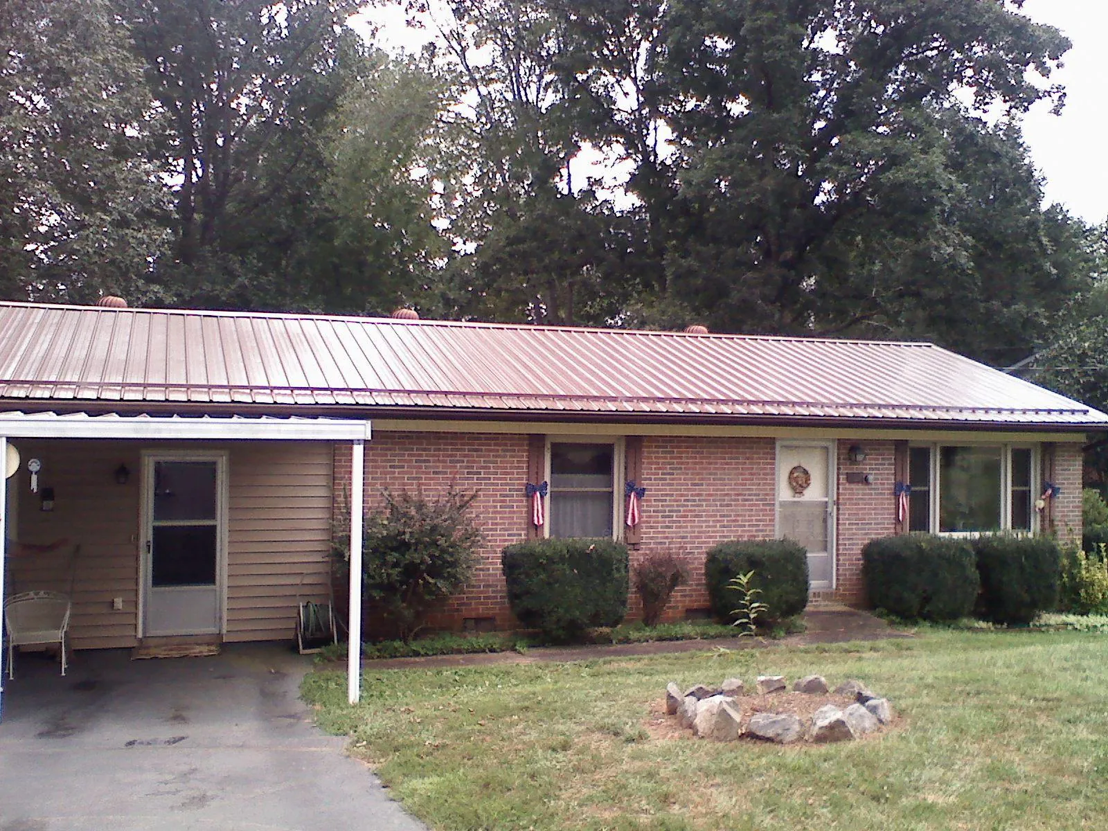 Bronze metal roof and carport on a brick ranch home — Roof Repair work by our crew in Whites Creek